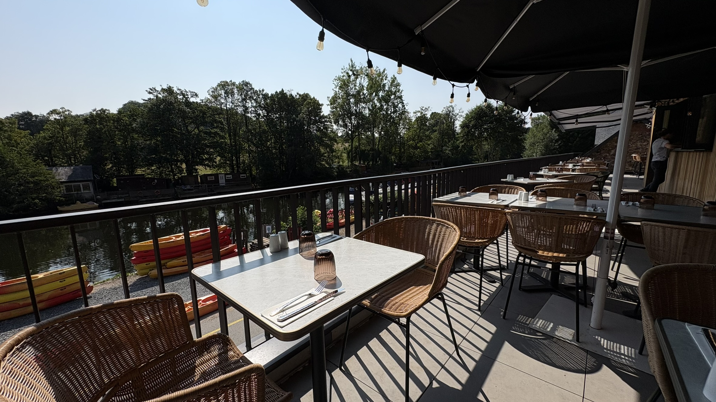 Une terrasse ensoleillée avec vue sur l'Orne et ses kayaks